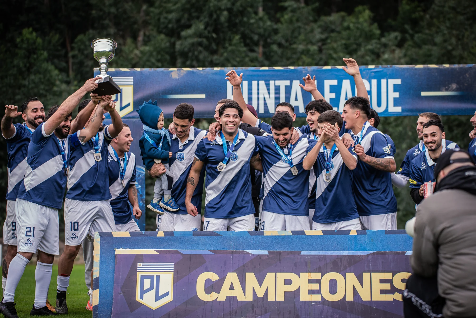 Jugadores celebrando juntos con la copa de Punta League